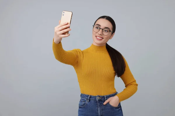 Jeune Femme Souriante Prenant Selfie Avec Smartphone Sur Fond Gris — Photo