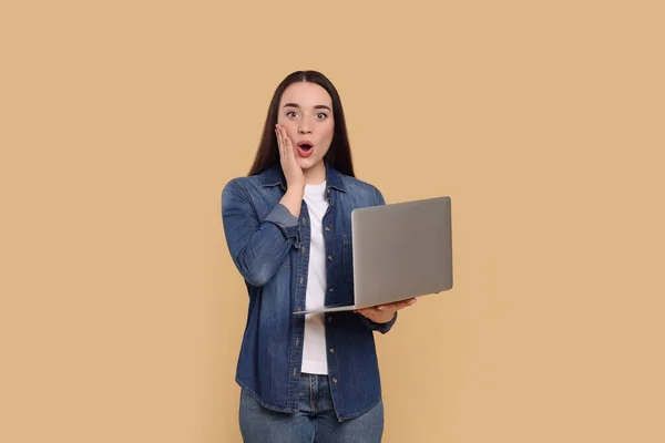 Bej Arka Planda Dizüstü Bilgisayarı Olan Şaşırmış Genç Bir Kadın — Stok fotoğraf