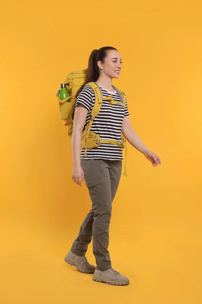 Χαμογελαστή Νεαρή Γυναίκα Σακίδιο Που Περπατάει Πορτοκαλί Φόντο Ενεργός Τουρισμός — Φωτογραφία Αρχείου