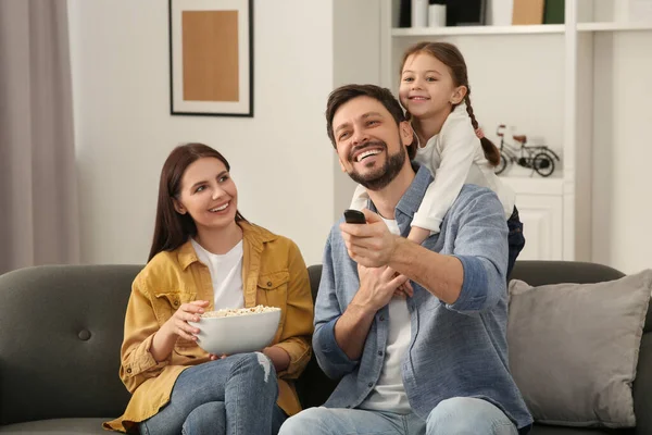 家庭で映画を見て幸せな家族 お父さんはリモコンでテレビチャンネルを変える — ストック写真