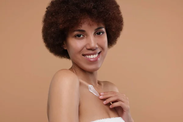 Hermosa Mujer Joven Aplicando Crema Cuerpo Sobre Fondo Beige —  Fotos de Stock