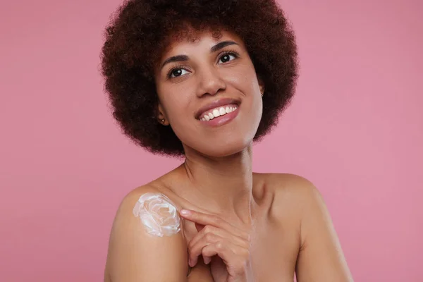 Mooie Jonge Vrouw Aanbrengen Lichaam Crème Schouder Roze Achtergrond — Stockfoto