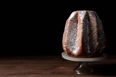 Tahta masaya pudra şekerle süslenmiş leziz Pandoro pastası, yazı için yer var. Geleneksel İtalyan pastası