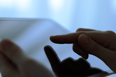 Bulanık arkaplanda modern tablet kullanan kadının yakın görüntüsü