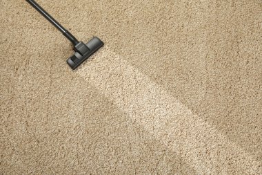 Elektrikli süpürgeyle halı süpürüyorum. Kirli yüzeyde temiz iz