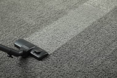 Elektrikli süpürgeyle halı süpürmek, mesaj için yer açmak. Kirli yüzeyde temiz iz