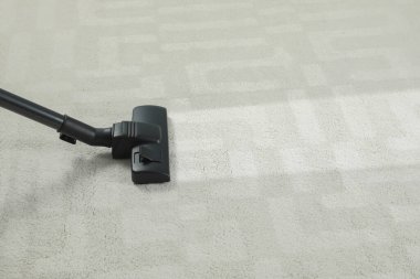 Elektrikli süpürgeyle halı süpürmek, mesaj için yer açmak. Kirli yüzeyde temiz iz
