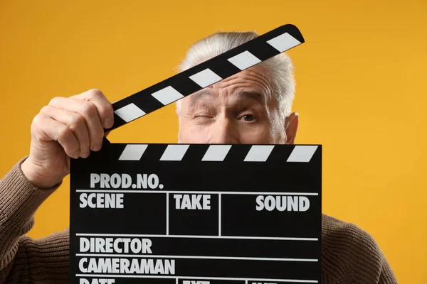 Senior Actor Holding Clapperboard Yellow Background Film Industry — Zdjęcie stockowe