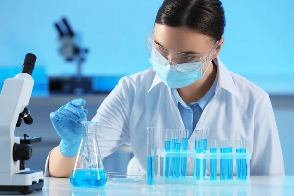 Bilim Adamı Laboratuarda Açık Mavi Sıvı Test Tüpleri Alıyor — Stok fotoğraf