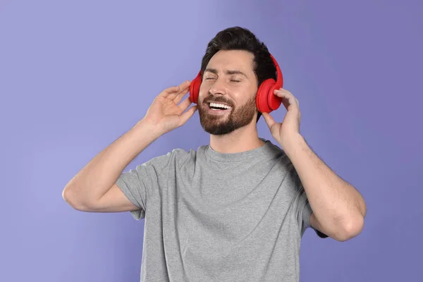 Щасливий Чоловік Слухає Музику Навушниками Фіолетовому Фоні — стокове фото