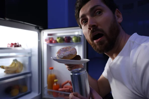 男人带着甜甜圈 晚上在厨房冰箱边喝酒 特写镜头 坏习惯 — 图库照片