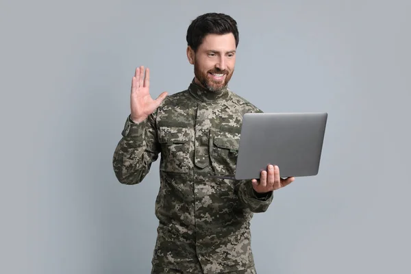 Ευτυχής Στρατιώτης Χρησιμοποιώντας Συνομιλία Βίντεο Στο Φορητό Υπολογιστή Ανοιχτό Γκρι — Φωτογραφία Αρχείου