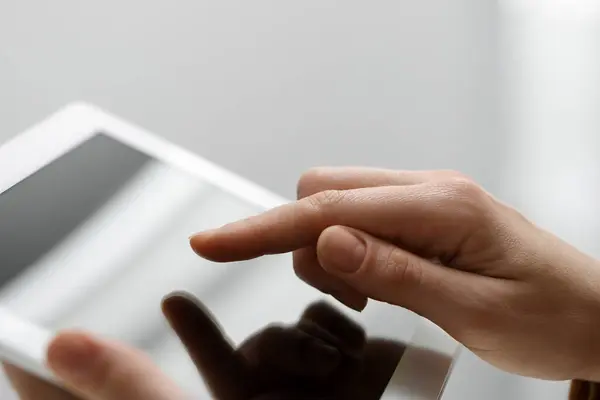 stock image Closeup view of woman using modern tablet on light grey background