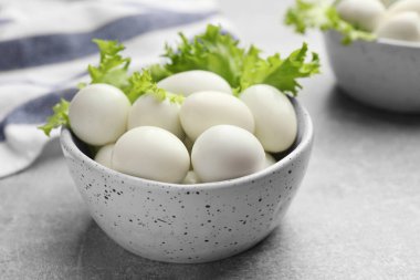 Gri masada kaynamış bıldırcın yumurtaları, yakın plan.