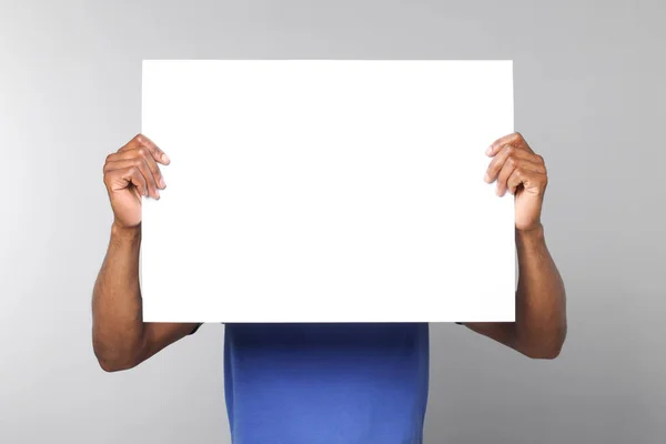 Afroamerikaner Mit Einem Blatt Papier Auf Grauem Hintergrund Mockup Für — Stockfoto
