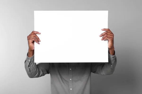 Afroamerikaner Mit Einem Blatt Papier Auf Grauem Hintergrund Mockup Für — Stockfoto