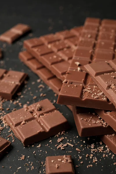 stock image Pieces of tasty chocolate bars on grey table, closeup