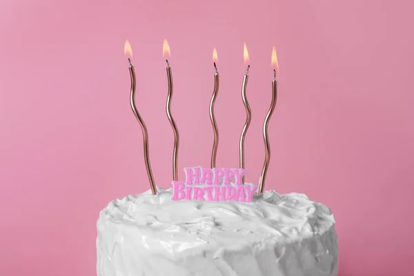 美味的蛋糕 奶油和燃烧的蜡烛粉红背景 — 图库照片