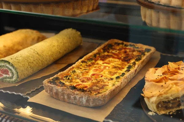 stock image Delicious quiche with cheese and broccoli on counter in bakery shop, closeup