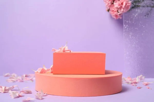 薄紫色の背景に幾何学模様とピンクのカーネーションの花を咲かせます 製品のためのスタイリッシュなプレゼンテーション — ストック写真