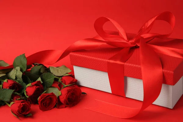 Schöne Geschenkschachtel Mit Schleife Und Rosen Auf Rotem Hintergrund — Stockfoto