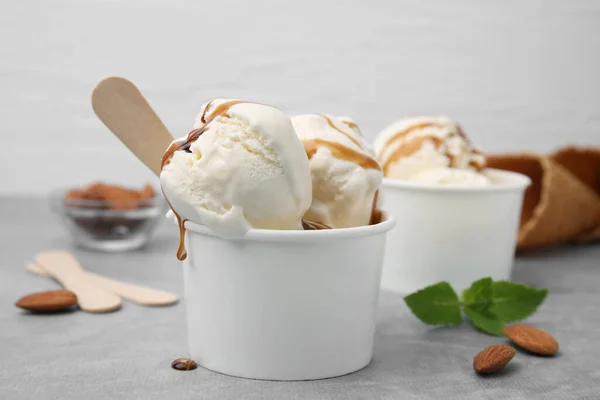 Мороженое Карамельным Соусом Бумажной Чашке Светло Сером Столе Крупным Планом — стоковое фото
