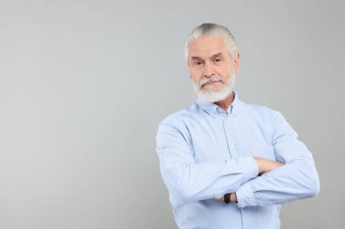 Açık gri arka planda yakışıklı yaşlı bir adamın portresi. Metin için boşluk