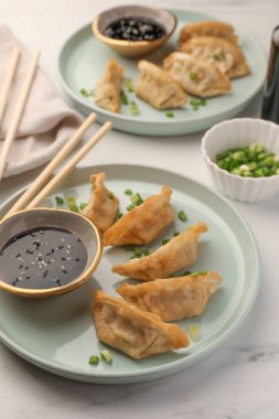 Soya soslu ve beyaz masada yeşil soğanlı lezzetli gyoza (Asya hamur tatlısı).