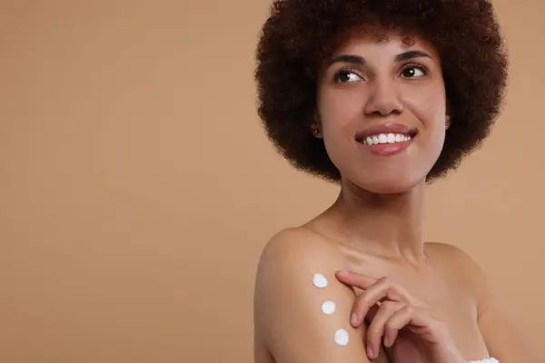 Mooie Jonge Vrouw Aanbrengen Lichaam Crème Arm Beige Achtergrond Ruimte — Stockfoto