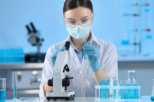 Testbuis Voor Wetenschappers Met Lichtblauwe Vloeistof Microscoop Het Laboratorium — Stockfoto