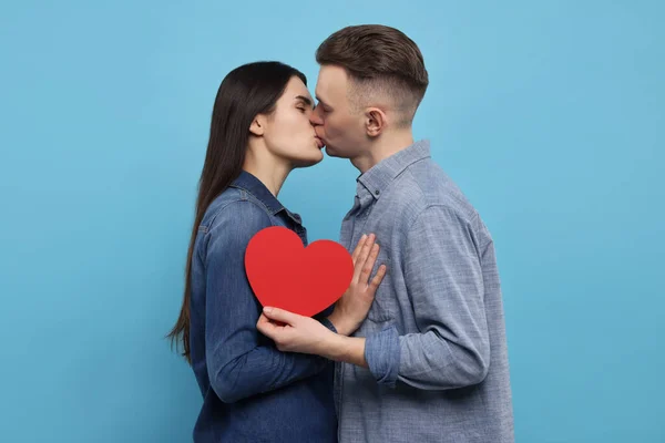 Joli Couple Avec Coeur Décoratif Embrassant Sur Fond Bleu Clair — Photo