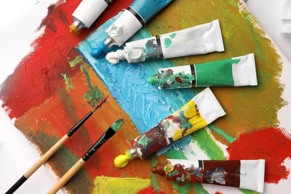 Tubos Tintas Óleo Coloridas Pincéis Sobre Tela Com Pintura Abstrata — Fotografia de Stock