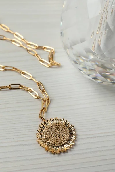 stock image Necklace and bottle of perfume on white wooden table, closeup