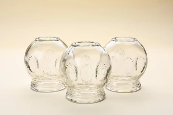 Glass cups on beige background. Cupping therapy