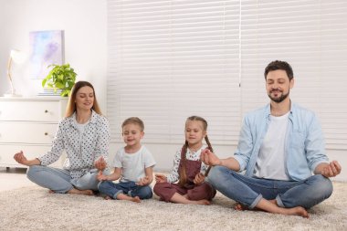 Aile evde meditasyon yapıyor. Ahenk ve zen