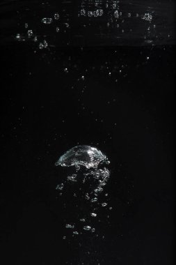 Siyah zemin üzerinde suda hava kabarcıkları