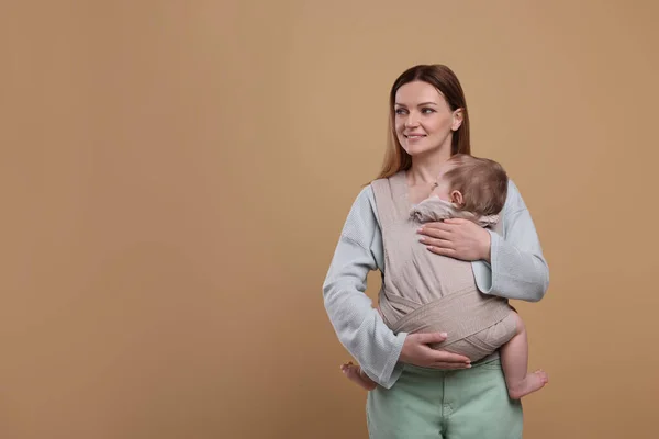 Mor Håller Sitt Barn Lyftsele Baby Bärare Ljusbrun Bakgrund Plats — Stockfoto