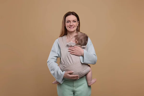 Moeder Houdt Haar Kind Draagdoek Babydrager Lichtbruine Achtergrond — Stockfoto
