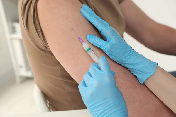 Læge Der Giver Hepatitis Vaccine Til Patienter Klinik Closeup - Stock-foto