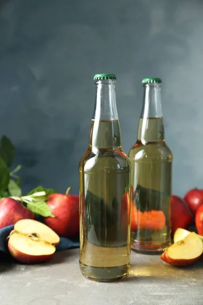 Köstlicher Apfelwein Und Äpfel Mit Grünen Blättern Auf Grauem Tisch — Stockfoto