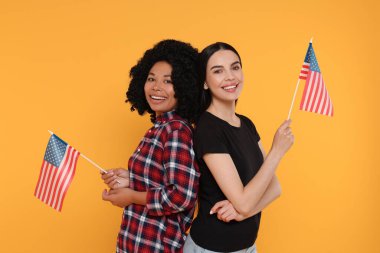 4 Temmuz - ABD 'nin Bağımsızlık Günü. Sarı arka planda Amerikan bayrakları olan mutlu kadınlar