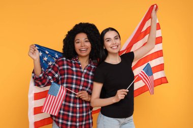 4 Temmuz - ABD 'nin Bağımsızlık Günü. Sarı arka planda Amerikan bayrakları olan mutlu kadınlar