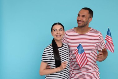 4 Temmuz - ABD 'nin Bağımsızlık Günü. Açık mavi arka planda Amerikan bayrakları olan mutlu çift, metin için alan