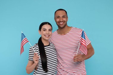 4 Temmuz - ABD 'nin Bağımsızlık Günü. Açık mavi arka planda Amerikan bayrakları olan mutlu çift