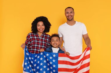 4 Temmuz - ABD 'nin Bağımsızlık Günü. Sarı arka planda Amerikan bayrağı olan mutlu aile.