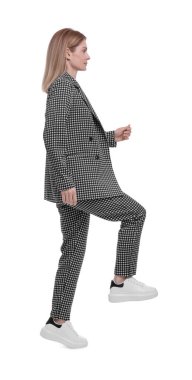 Beyaz arka planda yürüyen takım elbiseli güzel bir iş kadını.