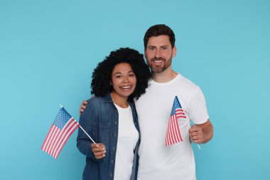 4 Temmuz - ABD 'nin Bağımsızlık Günü. Açık mavi arka planda Amerikan bayrakları olan mutlu çift