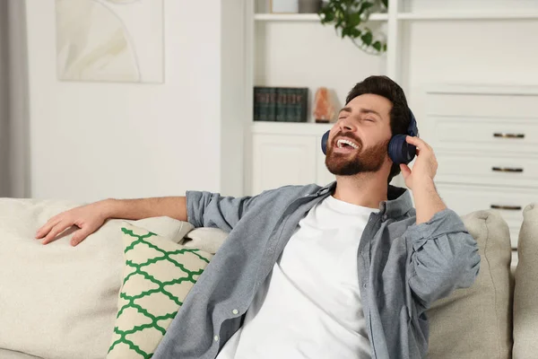 快乐的男人在屋里用耳机听音乐 — 图库照片