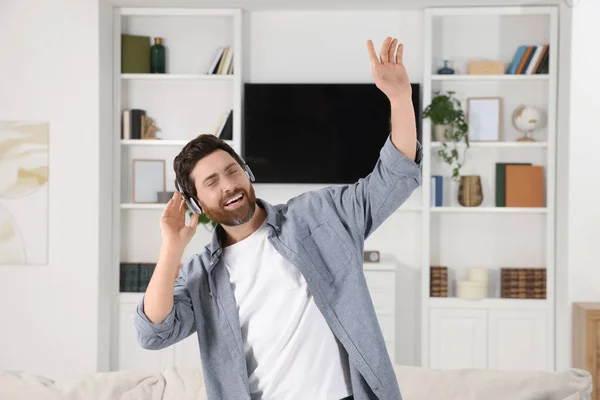 一个情绪化的男人一边在家里一边用耳机听音乐一边跳舞 — 图库照片