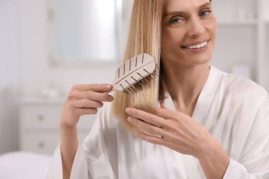 Odada saçını tarayan güzel bir kadın.